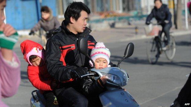 Man carries children on his motorbike