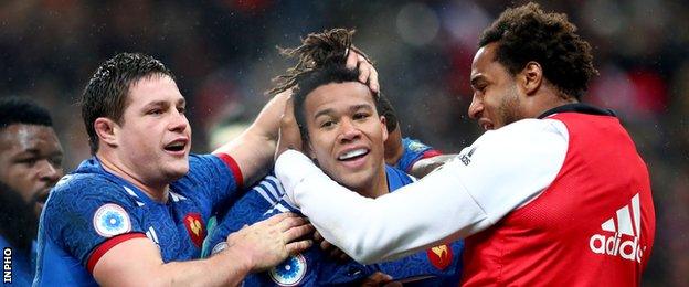 France's Henry Chavancy and Benjamin Fall celebrate with try scorer Teddy Thomas