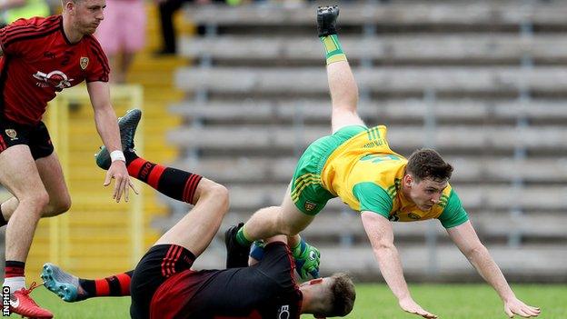 Donegal forward Jamie Brennan tangles with Down goalkeeper Marc Reid at Clones