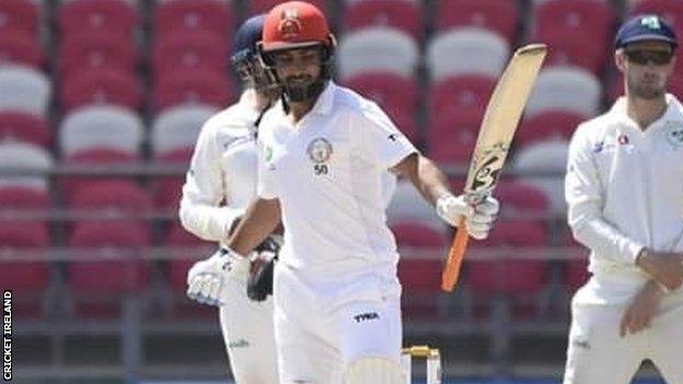 Insanullah Janat acknowledges applause after reaching his 50 in Dehradun