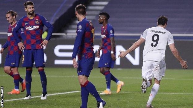 Gerard Pique (second from left) watches on as Robert Lewandowski celebrates scoring for Bayern Munich