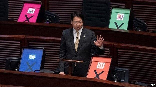 Hong Kong pro-democracy lawmaker Charles Mok addresses the city's legislature next to placards symbolising a vote against the government's controversial electoral roadmap, in Hong Kong on June 18, 2015