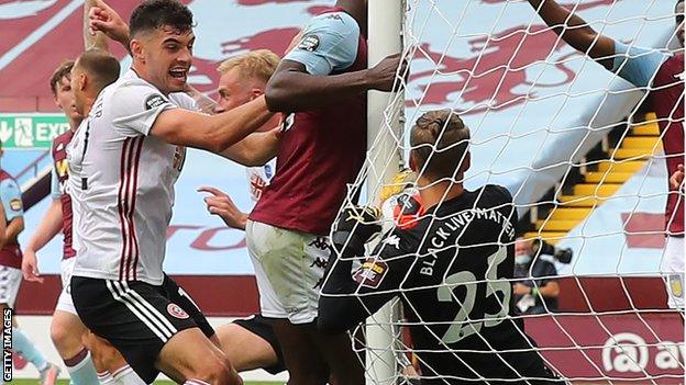 Aston Villa goalkeeper Orjan Nyland holds the ball behind the goalpost