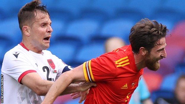 Joe Allen of Wales is pushed by Amir Abrashi