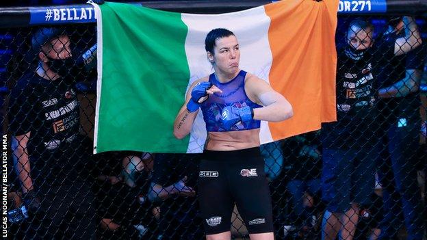 Sinead Kavanagh in front of an Irish flag in the cage