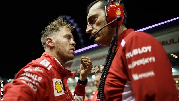 Sebastian Vettel in conversation with a Ferrari engineer