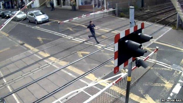 Man running across level crossing