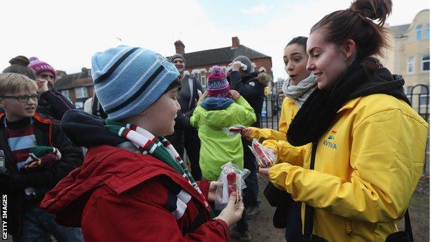 A steward hands out rainbow laces ahead of the Aviva Premiership game between Leicester Tigers and Worcester Warriors