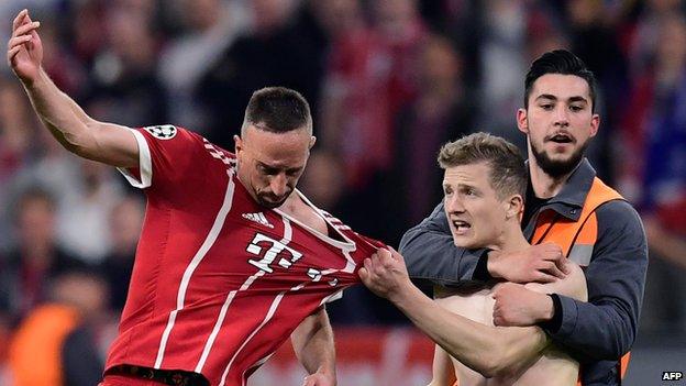 Pitch invader grabs shirt of Frank Ribery