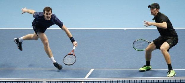 Jamie Murray of Britain, left hits a return watched by his playing partner John Peers of the United States to Bob Bryan and Mike Bryan of the United States during their doubles match