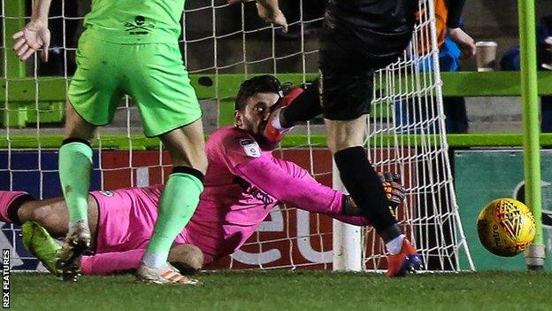 Forest Green Rovers goalkeeper James Montgomery takes a boot to the face