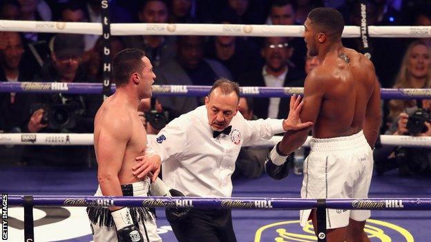 Boxing referee holds Anthony Joshua and Joseph Parker apart