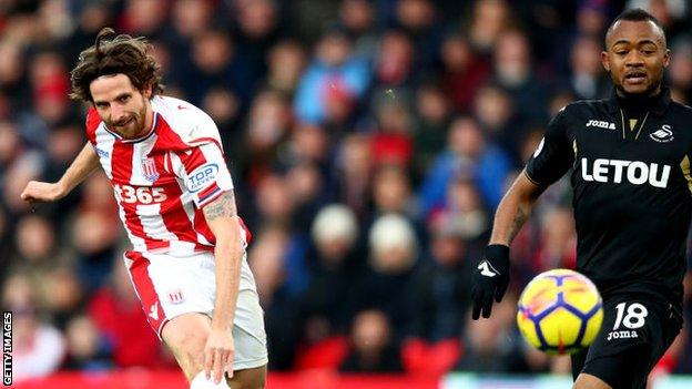 Joe Allen shoots as Jordan Ayew looks on