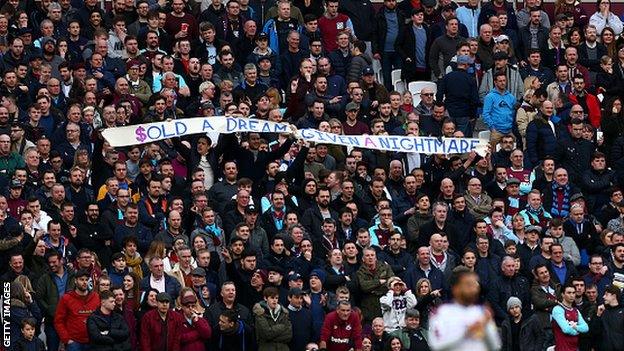 West Ham fans hold a banner protesting against the club's board