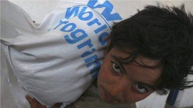 A boy receives humanitarian aid in Duma, Damascus March 29, 2014