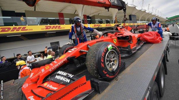 Sebastian Vettel's damaged car is taken back to the garage