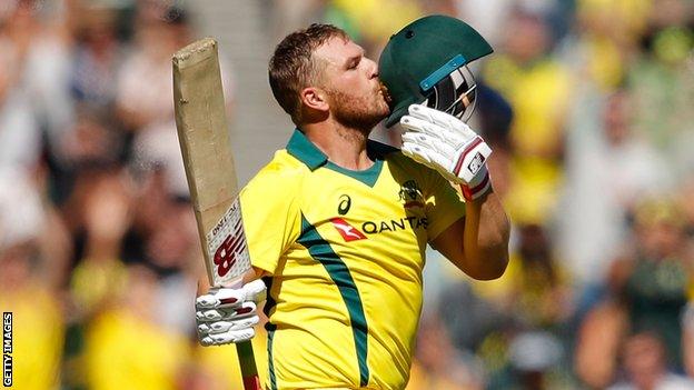 Australia's Aaron Finch kisses the badge on his helmet after reaching a century against England