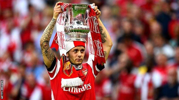 Jack Wilshere holds the FA Cup on top of his head after winning with Arsenal