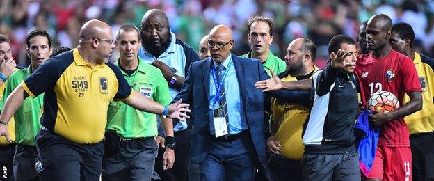 Officials led off the pitch by security