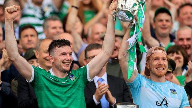 Limerick captain Declan Hannon lifts the Liam McCarthy Cup with injured player Cian Lynch