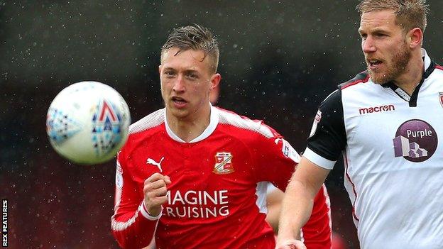 Swindon striker Luke Norris (left) battles for the ball with Morecambe defender Steven Old