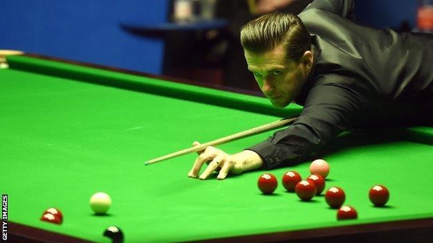 Mark Selby stretches to play a shot