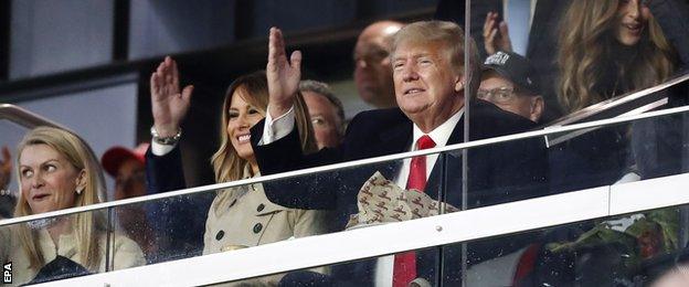 Former US President Donald Trump does the 'tomahawk chop' gesture at Truist Park during game foiur