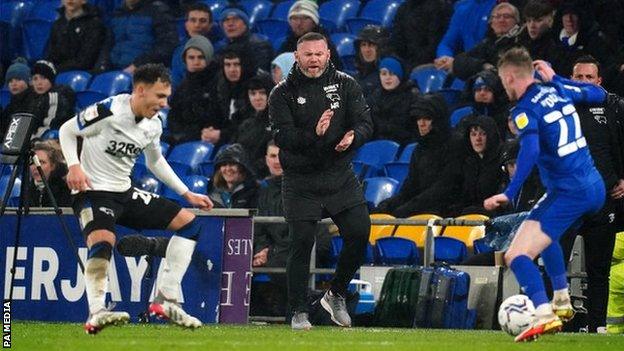 Derby County manager Wayne Rooney (centre) encourages his players from the sideline