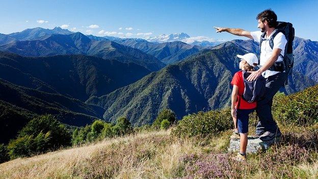 Man and boy walking across peaks.