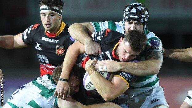 Elliot Dee of Dragons is tackled by Ben Sowrey and Gary Graham