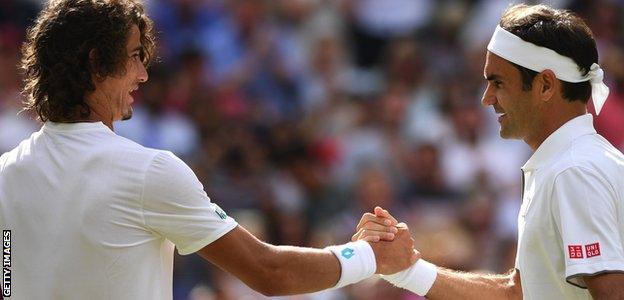 Lloyd Harris and Roger Federer shake hands after their first round match at Wimbledon in 2019