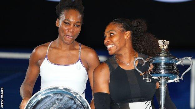 Venus Williams and Serena Williams pose with their Australian Open trophies after the 2017 final