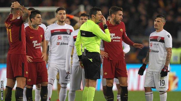 Roma and Cagliari players react to a decision using VAR in Serie A