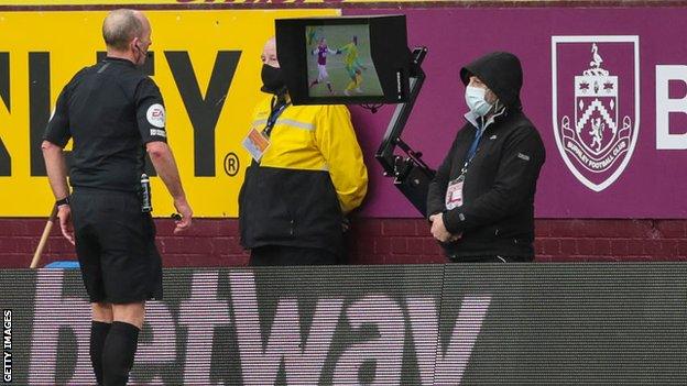 Referee Mike Dean consults VAR