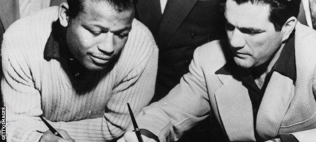 Sugar Ray Robinson and Joey Maxim sign their fight contracts ahead of their fight in 1952