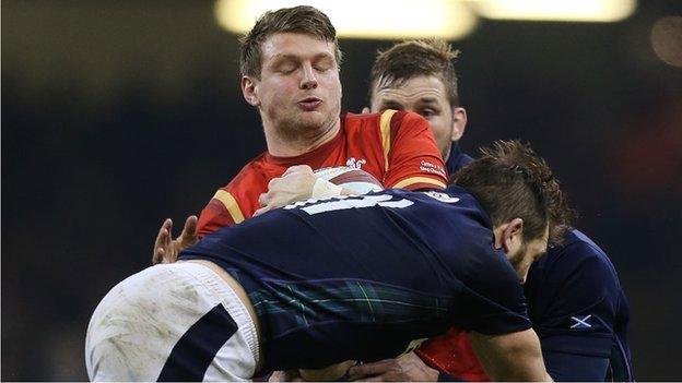 Dan Biggar is tackled by a Scotland defender