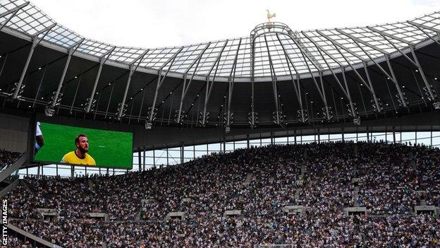 Harry Kane on a big screen above Spurs fans at the Tottenham Hotspur Stadium