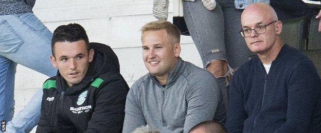 Hibernian midfielder John McGinn (left) watches the game from the stand