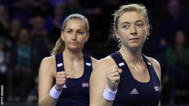 Olivia Nicholls and Alicia Barnett clench their fists during a Billie Jean King Cup Finals match for Great Britain