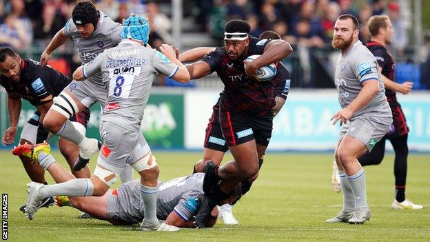 Saracens' Eroni Mawi (centre) is tackled by Bath's Juan Schoeman