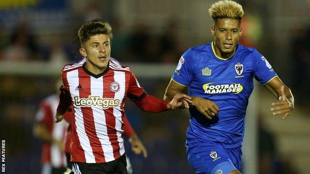 Brentford defender Ilias Chatzitheodoridis and AFC Wimbledon striker Lyle Taylor compete for the ball