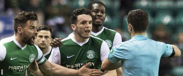 Hibernian players with referee Nick Walsh