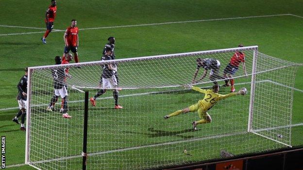 Dean Henderson makes a save against Luton