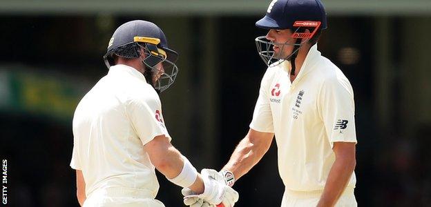 Alastair Cook celebrates reaching 12,000 Test runs by shaking hands with Mark Stoneman