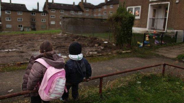 Children in coats sit on railing