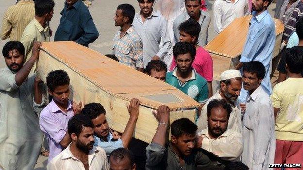 Pakistani Christian mourners carry the coffins of relatives killed in two bomb attacks on a church in Peshawar in September 2013