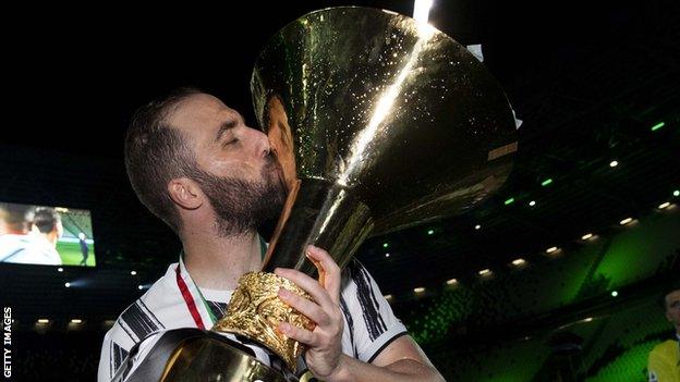 Gonzalo Higuain kisses the Serie A trophy after Juventus won the Italian league