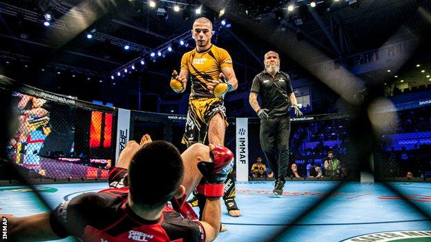 Muhammad Mokaev beckons his opponent on his feet after a knockdown