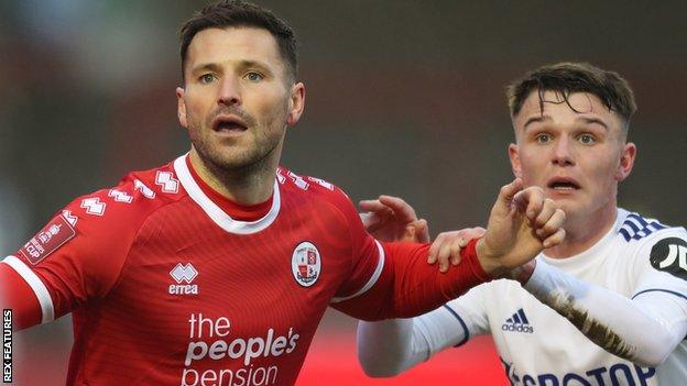 Crawley's Mark Wright (left) challenges for the ball