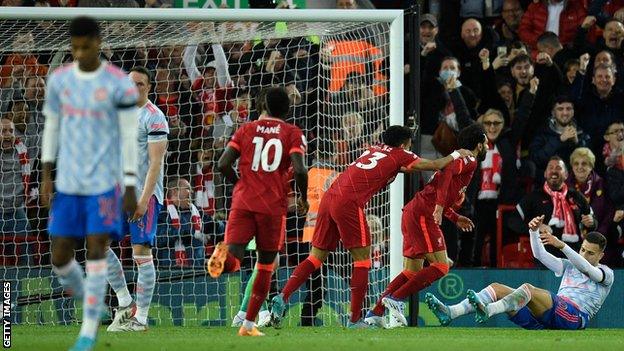 Manchester United players look dejected as Liverpool celebrate scoring in their 4-0 win at Anfield